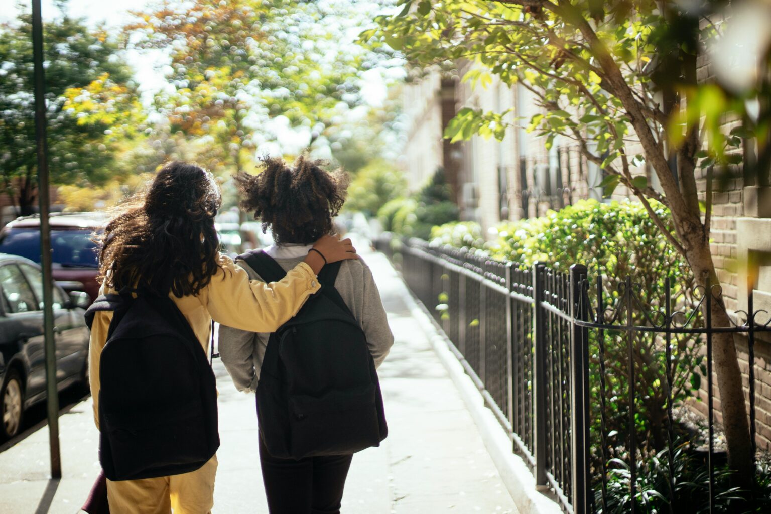 Teenage schoolgirls with backpacks walking together